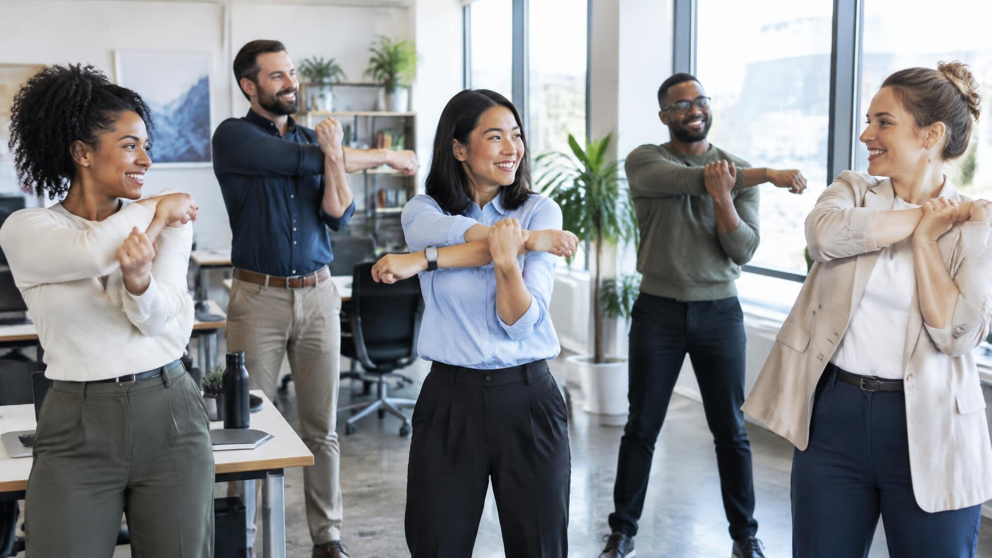Group of employees stretching together during an office wellness break