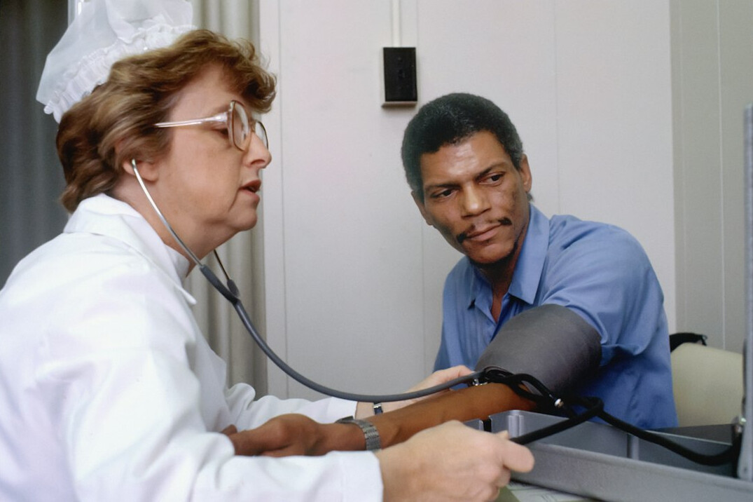 Health professional measuring blood pressure of an employee
